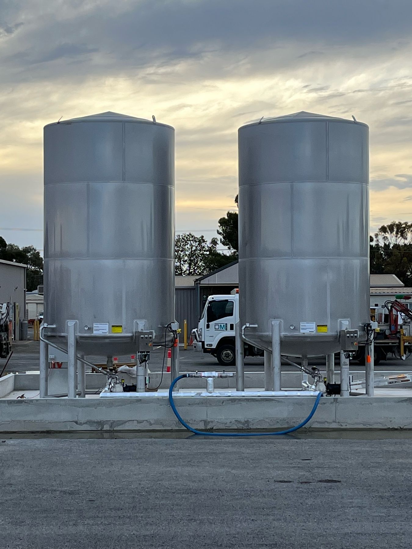 Pair of commissioned stainless emulsion tanks at dusk